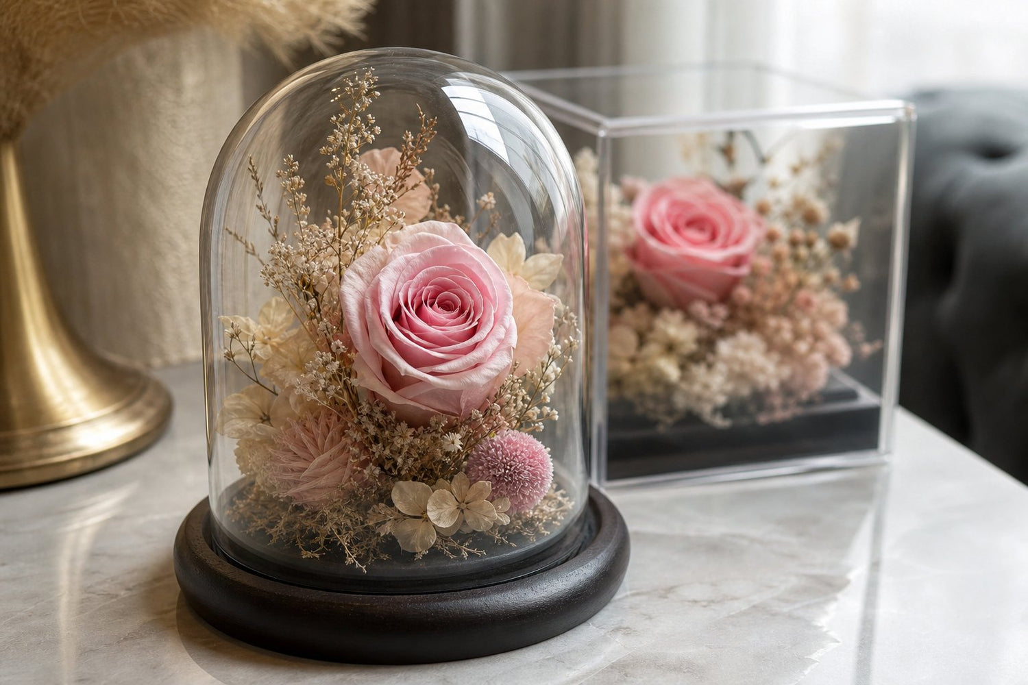 Close-up of preserved flowers in a glass dome and acrylic display showing real petal texture